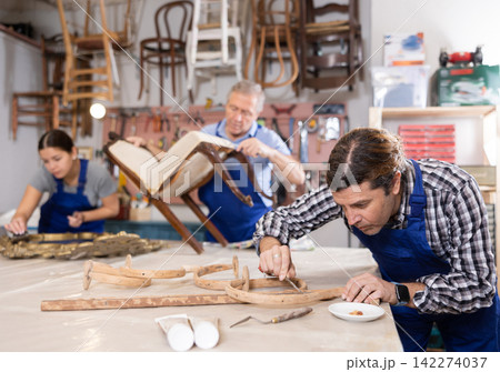 experienced male cabinetmaker restorer carefully cleans carved wooden decor element from dirt experienced male cabinetmaker restorer carefully cleans carved wooden decor element from dirt 142274037