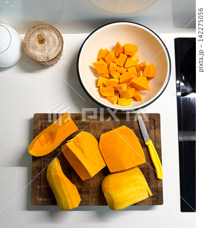 Preparing butternut squash for cooking in kitchen Preparing butternut squash for cooking in kitchen 142275056