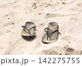 砂浜と黒いビーチサンダル 142275755