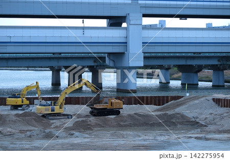 河川の下流で実施されている、治水対策の工事現場の一角(背後に都市高速の高架橋) 河川の下流で実施されている、治水対策の工事現場の一角(背後に都市高速の高架橋) 142275954