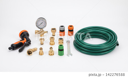 Garden hose coiled with spray nozzle and various brass fittings and connectors on white background fittings connectors watering equipment pressure irrigation agriculture accessory maintenance 142276588