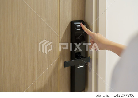 Hand using fingerprint scan for smart digital door lock while open or close the door at home or apartment. NFC Technology, keycard, PIN number, smartphone and contactless lifestyle concepts Hand using fingerprint scan for smart digital door lock while open or close the door at home or apartment. NFC Technology, keycard, PIN number, smartphone and contactless lifestyle concepts 142277806