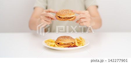 happy woman eating Juicy beef burger with melted cheddar cheese, potato chips. Unhealthy, High calorie, Fast food craving, Obesity, diet, weight loss, junk food and lifestyle happy woman eating Juicy beef burger with melted cheddar cheese, potato chips. Unhealthy, High calorie, Fast food craving, Obesity, diet, weight loss, junk food and lifestyle 142277901