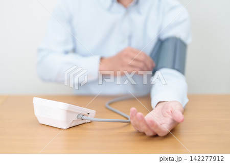 Man checking Blood pressure by Blood pressure monitor with Cuff. Systolic, SYS, Diastolic, DIA, Pulse, Hypertension, Hypotension, Heart rate, Cardiovascular Disease and May World hypertension day Man checking Blood pressure by Blood pressure monitor with Cuff. Systolic, SYS, Diastolic, DIA, Pulse, Hypertension, Hypotension, Heart rate, Cardiovascular Disease and May World hypertension day 142277912