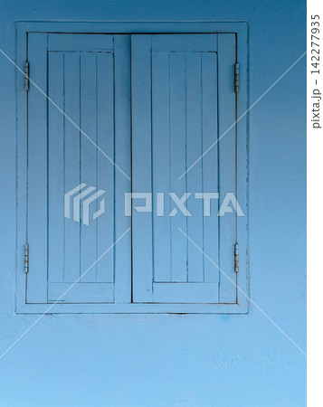 Blue pastel wooden window on light blue wall, monochromatic minimal architecture concept background with copy space. Blue pastel wooden window on light blue wall, monochromatic minimal architecture concept background with copy space. 142277935