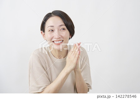 白背景で願う笑顔の40代女性 白背景で願う笑顔の40代女性 142278546