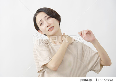 白背景で肩こりに苦しむ40代女性 白背景で肩こりに苦しむ40代女性 142278558