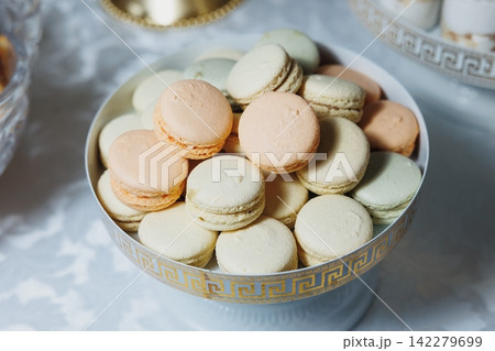 Pastel macarons nestled in elegant, patterned bowl Pastel macarons nestled in elegant, patterned bowl 142279699