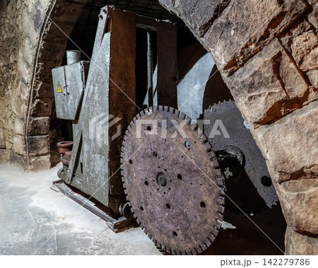 Vintage stone cutting machine inside underground wine cellars tunnel 142279786