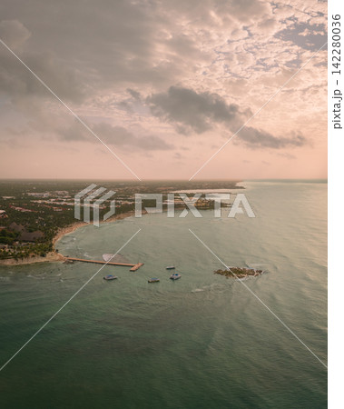 Panorama of sandy beach with wooden pier leading over Caribbean sea at sunset Panorama of sandy beach with wooden pier leading over Caribbean sea at sunset 142280036
