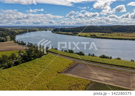 Aerial view of lush green rural land alongside the Clarence River at Maclean, showcasing open farmland, riverside vegetation and the broad waterway within the Northern Rivers region of NSW, Australia. Aerial view of lush green rural land alongside the Clarence River at Maclean, showcasing open farmland, riverside vegetation and the broad waterway within the Northern Rivers region of NSW, Australia. 142280375