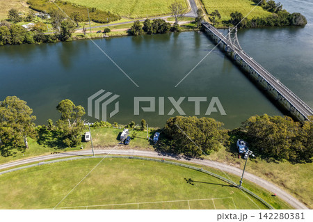 Aerial view of caravans set up alongside the Clarence River at Maclean Showground, featuring riverside camping, the broad waterway and the bridge visible in the background at Maclean Aerial view of caravans set up alongside the Clarence River at Maclean Showground, featuring riverside camping, the broad waterway and the bridge visible in the background at Maclean 142280381