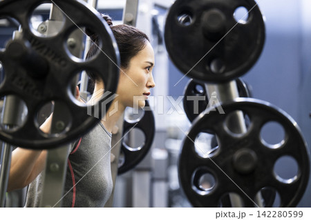 スポーツジムでトレーニングする若い女性 スポーツジムでトレーニングする若い女性 142280599