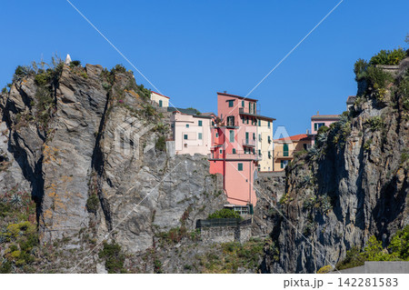 Manarola within Liguria, Italy with central pink building enclosed by rock Manarola within Liguria, Italy with central pink building enclosed by rock 142281583