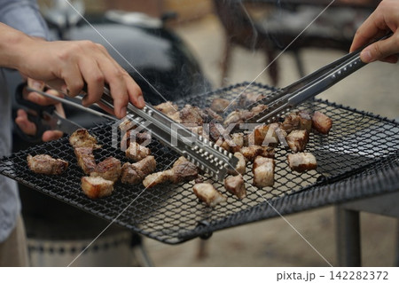 Close Up Hands Grilling Ribs Close Up Hands Grilling Ribs 142282372