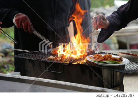 Chopsticks Turning Pork On Flame 142282387