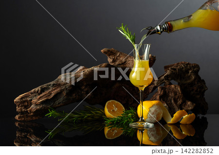 Traditional Italian liqueur Limoncello on a black reflective background. Traditional Italian liqueur Limoncello on a black reflective background. 142282852