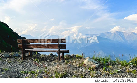 Wooden bench overlooking dramatic Caucasus mountain landscape Wooden bench overlooking dramatic Caucasus mountain landscape 142283969