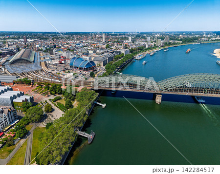 High angle wide horizontal aerial drone photograph of Hohenzollern Bridge, Rhine river, Central Station, Musical Dome, and city skyline in Cologne, North Rhine-Westphalia, Germany, Central Europe 142284517