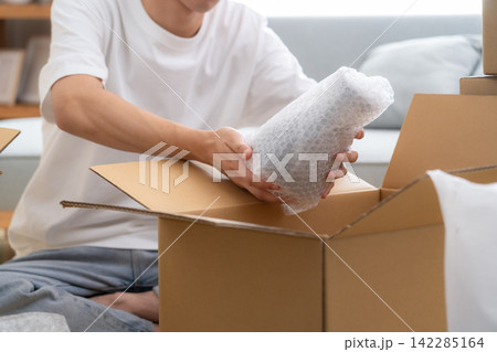 引っ越しの荷造りをする若い男性 引っ越しの荷造りをする若い男性 142285164