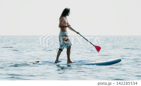 Paddleboarding, Water Sports, Man on Paddleboard Enjoying the Calm Sea Paddleboarding, Water Sports, Man on Paddleboard Enjoying the Calm Sea 142285534