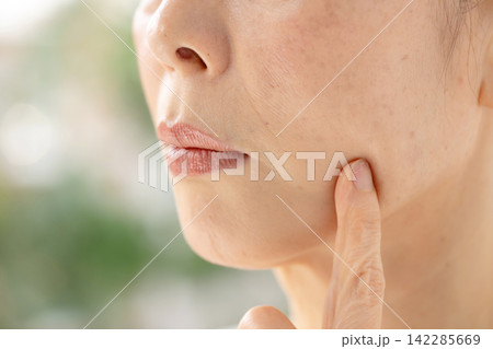 頬を触る女性 悩む 頬を触る女性 悩む 142285669