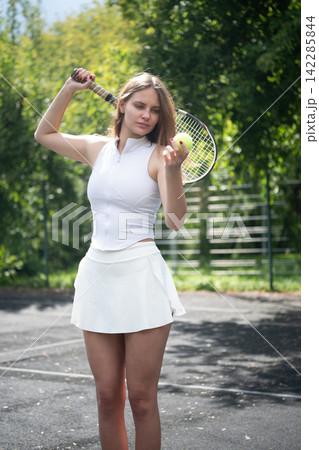 Focused female tennis player examining ball before match 142285844