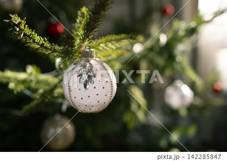 White Christmas ornament hanging on natural fir tree White Christmas ornament hanging on natural fir tree 142285847