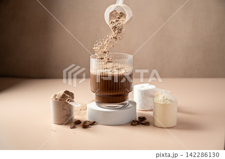 Chocolate protein powder pouring in a glass. Food supplement, fitness sport, health and nutrition. 142286130