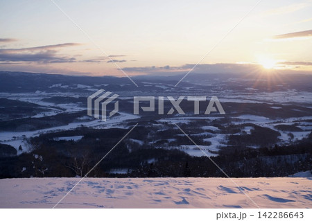 雪の丘から見る夕日と広い平野 雪の丘から見る夕日と広い平野 142286643