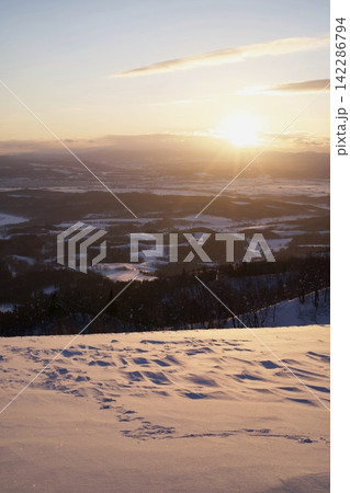 雪の丘から望む夕日と平野 雪の丘から望む夕日と平野 142286794