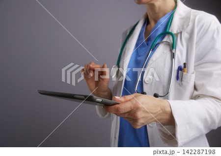 Medical Professional Managing Records on Digital Tablet Medical Professional Managing Records on Digital Tablet 142287198