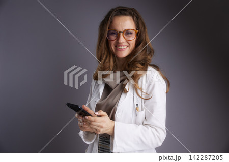 Approachable Female Physician Holding a Smartphone Approachable Female Physician Holding a Smartphone 142287205