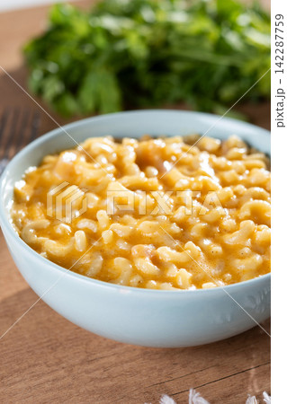 Traditional mac and cheese in bowl on wooden table 142287759