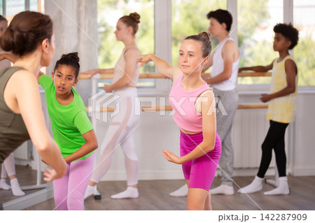 Teenage girls doing choreography with instructor during ballet classes Teenage girls doing choreography with instructor during ballet classes 142287909