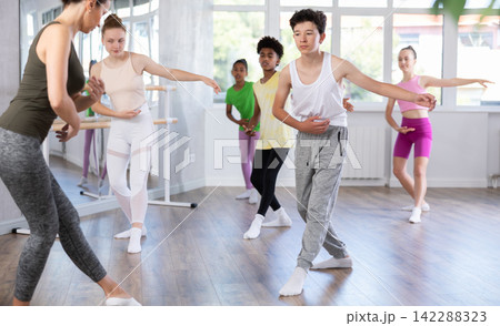 Amateur teenage boy practicing ballet positions standing in row with others Amateur teenage boy practicing ballet positions standing in row with others 142288323