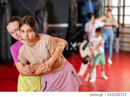 Girls practice self-defense strikes in the gym Girls practice self-defense strikes in the gym 142288352