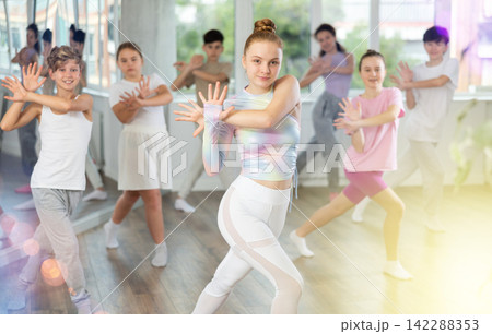 Woman teacher in background dances with students, inspects and observes skill of dancers Woman teacher in background dances with students, inspects and observes skill of dancers 142288353