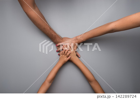 Family clasping hands in a teamwork concept Family clasping hands in a teamwork concept 142289724