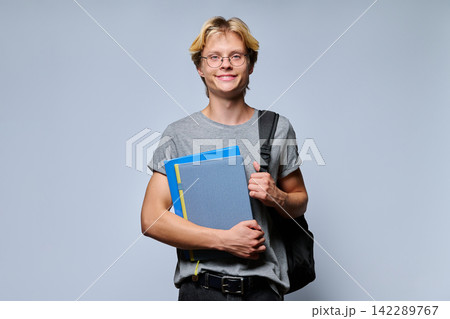Portrait of smiling teenage student with notebooks and backpack Portrait of smiling teenage student with notebooks and backpack 142289767