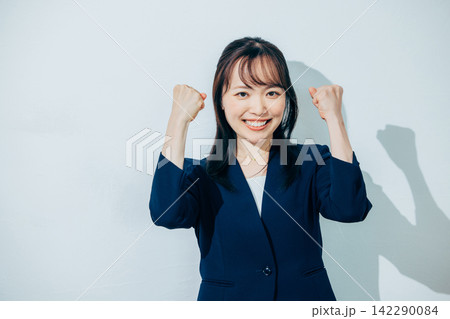 笑顔でガッツポーズをする女性 笑顔でガッツポーズをする女性 142290084