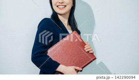 ファイルを持ったスーツの女性 ファイルを持ったスーツの女性 142290094