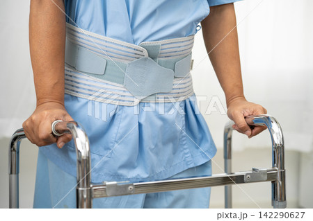 Asian lady patient wearing back pain support belt for orthopedic lumbar with walker. Asian lady patient wearing back pain support belt for orthopedic lumbar with walker. 142290627