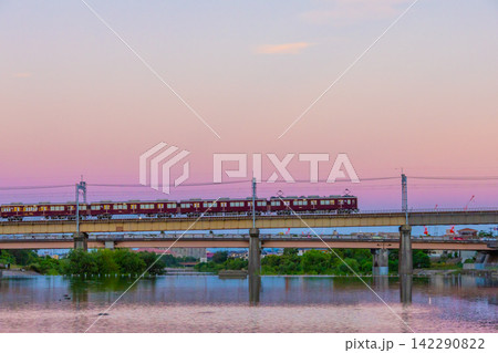 トワイライトに染まる武庫川と阪急電車　兵庫県宝塚市の夕暮れの鉄道風景 142290822