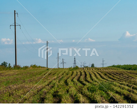 Rural electrification process with power lines extending across remote agricultural fields 142291352
