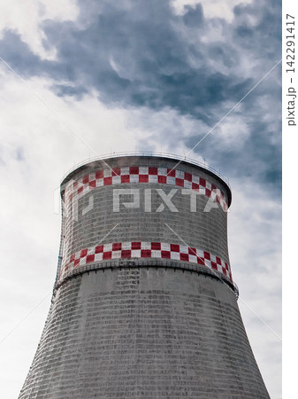 Cooling tower of an industrial plant or thermal power plant against a blue sky Cooling tower of an industrial plant or thermal power plant against a blue sky 142291417