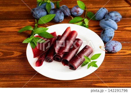 Traditional plum fruit leather dessert served with fresh plums Traditional plum fruit leather dessert served with fresh plums 142291796