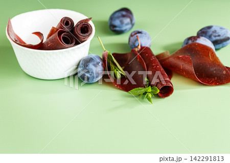 Homemade dried plum dessert with rolls on green background Homemade dried plum dessert with rolls on green background 142291813