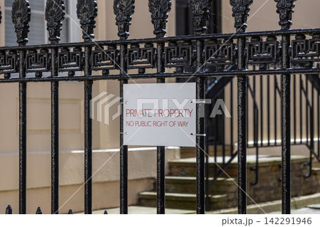 Private property sign mounted on ornamental wrought iron fence 142291946