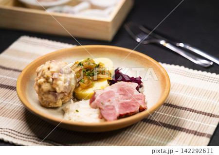 Bavarian dumplings with roasted pork, sauerkraut and potato dumpling lying on a plate 142292611